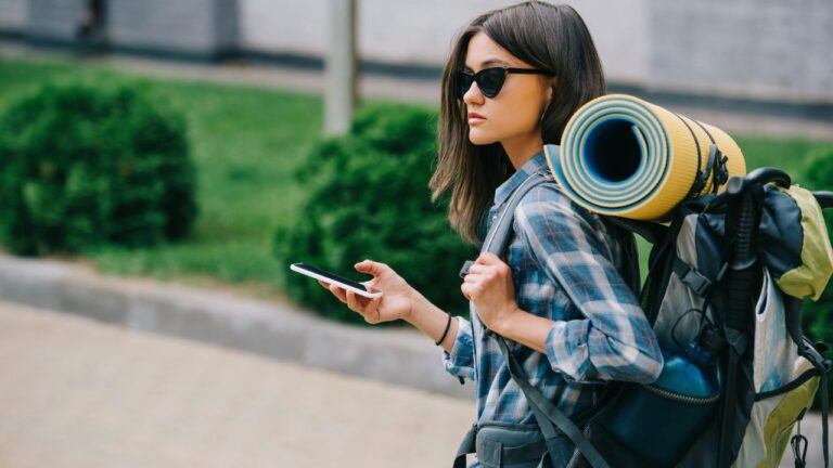 Young woman walking with phone in hand