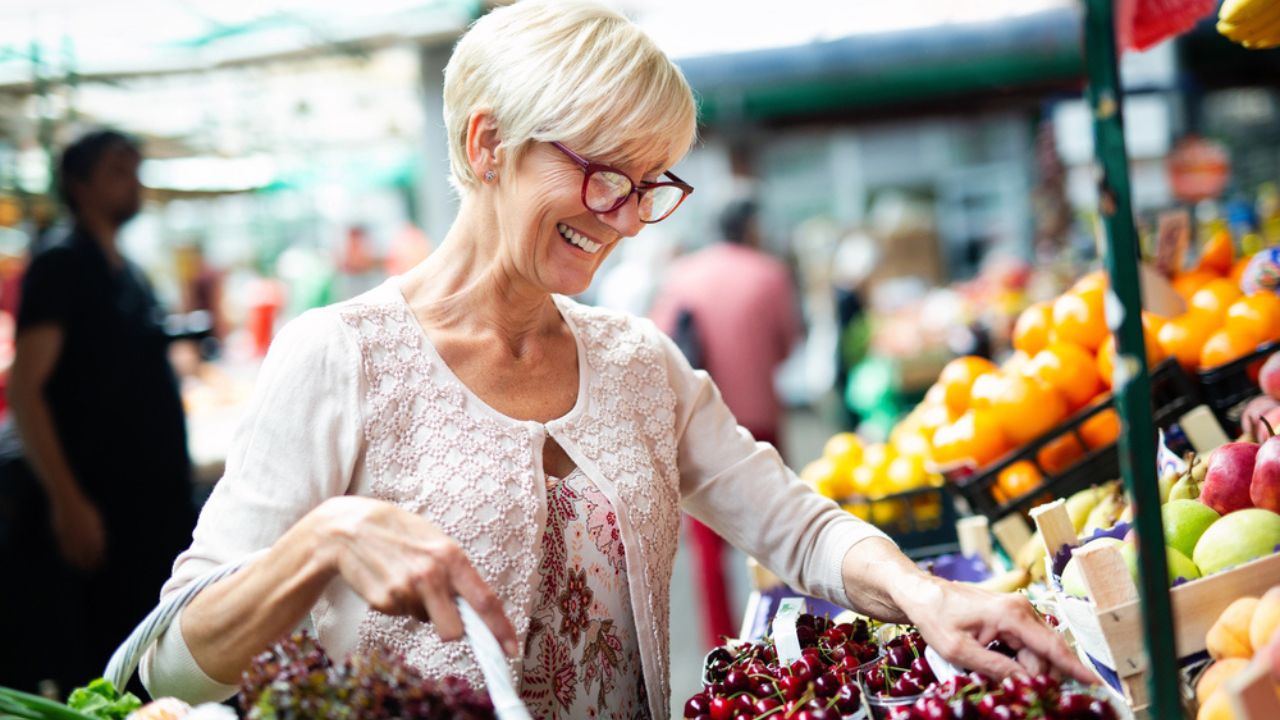 Smiling senior getting fruits in the grocery.